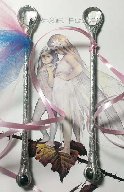 A picture of two fairies with ribbons around them.